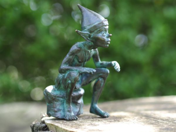Bronzefigur Pixi sitzend auf Stein